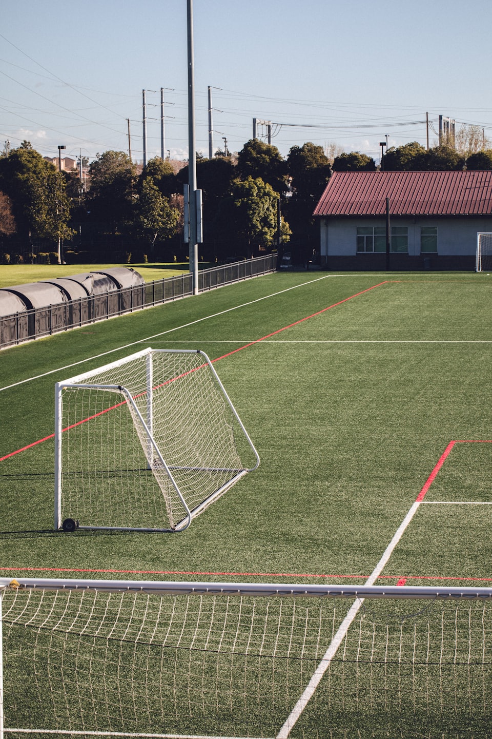 Fußballfeld mit Toren und leuchtend grünem Kunstrasen.